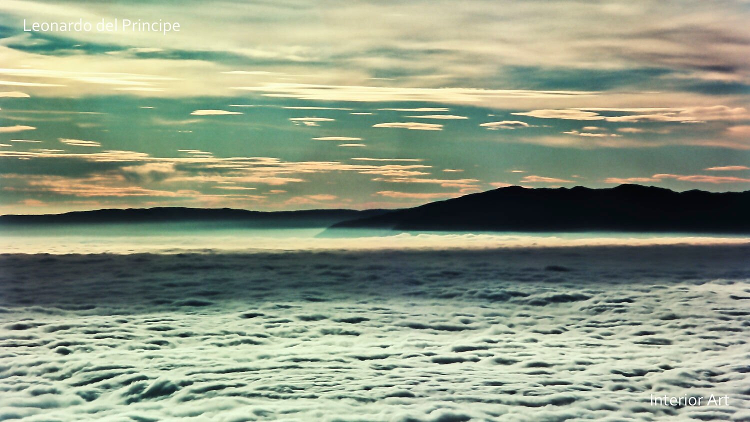 PUMO05 Serene seascape at dawn with a soft, cloudy sky in pastel hues of orange and blue. A dark silhouette of distant hills adds depth to the tranquil scene.