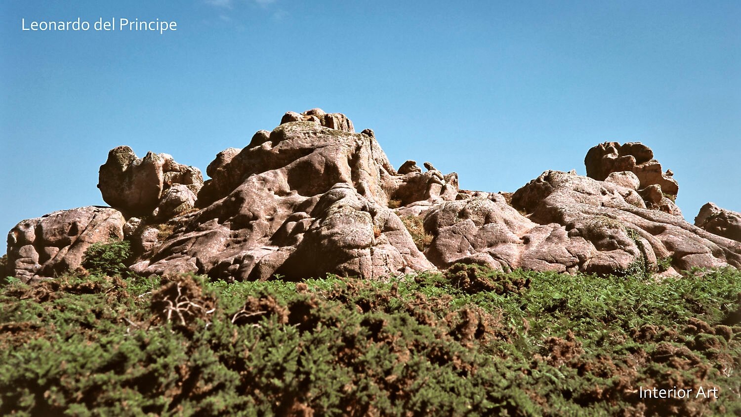 GOGR01 Rocky granite formations under a clear blue sky, surrounded by lush green foliage, convey a sense of natural beauty and grandeur.