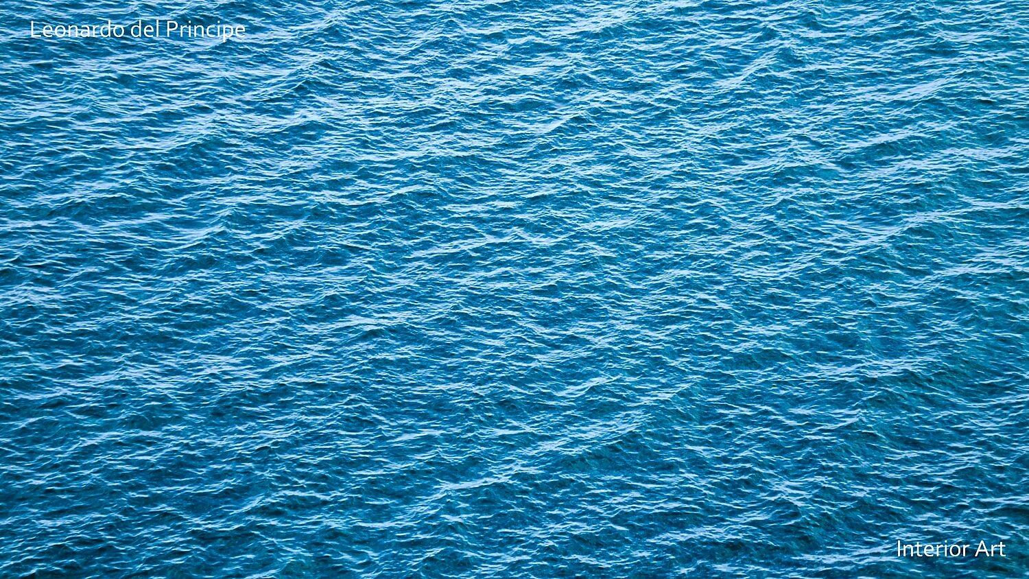 ESEAa03 A tranquil sea surface with gentle waves under clear blue skies, showcasing a rich blue hue. The scene conveys a sense of calm and serenity.